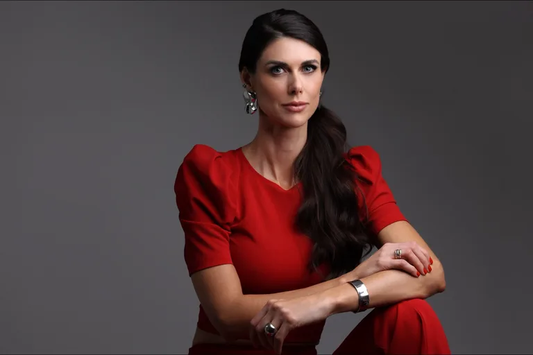 Dra. Monique Bins sentada, usando vestido vermelho